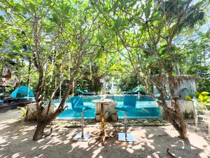 een tafel en stoelen voor het zwembad bij Eagleye Langkawi in Tanjung Rhu