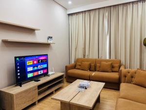 JuffairにあるCity lights endless nightsのソファと薄型テレビのあるリビングルーム