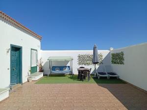 a patio with a gazebo and a table and chairs at Live Abades Playa y terraza in Abades