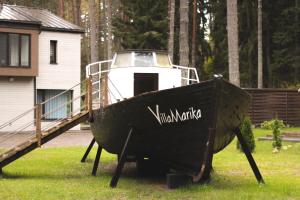 AlajõeVilla MARIKA plus的房子旁边的草地上展示的一艘船