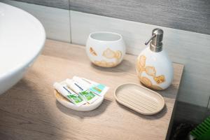 a bathroom counter with a sink and toothbrushes and a cup at Casa Vacanze Manzoni 29 in Cagliari +16 photos