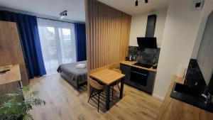 a room with a kitchen and a table with a tableablish at Apartament - Sienkiewicza 22D in Zamość