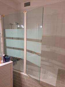 una ducha con puerta de cristal en un baño en Les grands prés, en Aytré