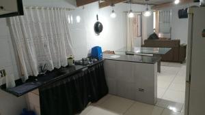a kitchen with a counter top and a stove at Casa monguagua in Mongaguá