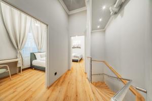 a white room with a staircase and a bedroom at Hive 5 by HOME1 - District 8 Boutique Hostel in Vienna +19 photos