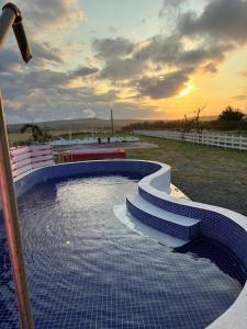 Una piscina con escaleras y una puesta de sol al fondo. en 墾丁高都莊園, en Nanwan