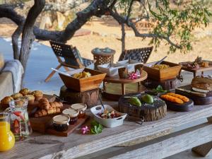 a table with many different types of food on it at Toro River by NEWMARK in Makalali Game Reserve