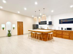 a kitchen with a wooden table and stools at Villa Sabanya Sea View in Ban Nua