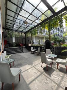 a patio with tables and chairs under a glass roof at K Hotel Kaliurang in Yogyakarta