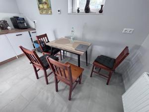 Una cocina con una mesa y sillas y una mesa y una computadora portátil. en Bezpieczna Przystań, en Frombork