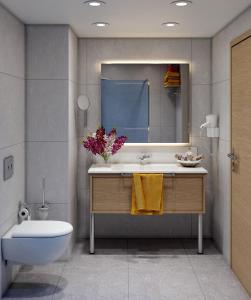 a bathroom with a sink and a toilet and a mirror at Azure By Yelken Hotel in Turgutreis