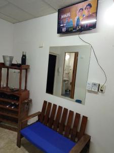 Habitación con banco y TV en la pared en Como en casa, en Formosa