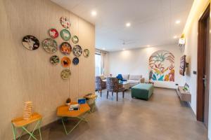 a living room with plates on the wall at SaffronStays Pebble House - 3BR riverside villa with glass walls, terraces & Nun River views, Dehradun in Dehradun