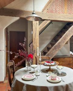 una mesa de comedor con un mantel blanco y flores en Maison avec piscine & tennis partagés - proche Châteaux de la Loire - 1h30 de Paris, en Combreux