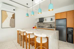 een keuken met een marmeren aanrecht en barkrukken bij Ocean Verve Villa 2 - 3bd in central Uluwatu in Bingin Beach