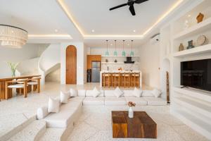 een woonkamer met een witte bank en een tafel bij Ocean Verve Villa 2 - 3bd in central Uluwatu in Bingin Beach