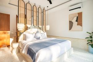 een slaapkamer met een wit bed en een blauwe deken bij Ocean Verve Villa 2 - 3bd in central Uluwatu in Bingin Beach