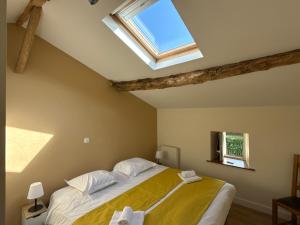 a bedroom with a large bed with a skylight at Gite du milieu - 8 personnes en pleine campagne et rivière By Primo in La Forêt-sur-Sèvre