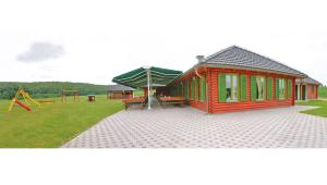 uma pequena casa com um parque infantil num campo em Guest accomodation Lovacka kuca em Grdak