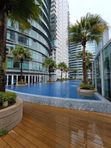 クアラルンプールにあるKLCC Sky Villa Suites Vortexのヤシの木が茂る建物の中央にあるスイミングプール