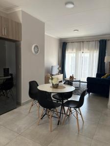 a kitchen and living room with a table and chairs at Haven & Beyond in Gaborone