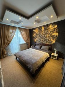 a bedroom with a large bed with a large headboard at Slāvu Dzīvoklis in Rīga