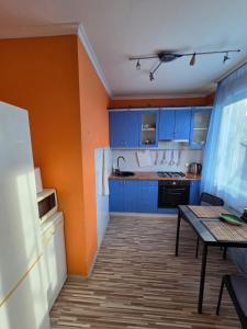 a kitchen with blue cabinets and a table in it at Slāvu Dzīvoklis in Rīga