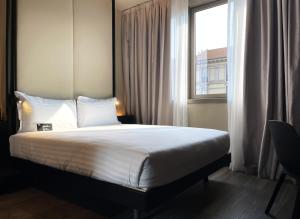 a bed in a hotel room with a window at 7BA Hotel Milano in Milan +8 photos
