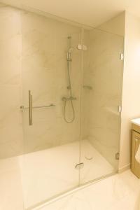 una ducha con puerta de cristal en un baño en Zenao Appart'hôtels Saint-Mandé, en Saint-Mandé 7 fotos más