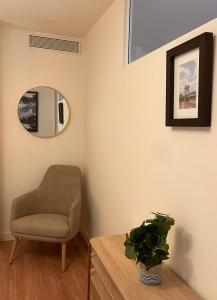 una silla y una mesa en una habitación con espejo en Zenao Appart'hôtels Saint-Mandé, en Saint-Mandé