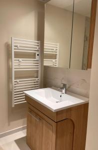 a bathroom with a white sink and a mirror at Zenao Appart'hôtels Saint-Mandé in Saint-Mandé +5 photos