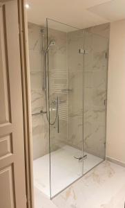 y baño con ducha y puertas de cristal. en Zenao Appart'hôtels Saint-Mandé, en Saint-Mandé