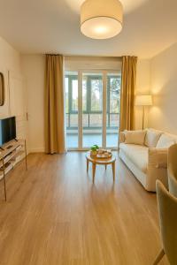 una sala de estar con un sofá y una mesa en Zenao Appart'hôtels Saint-Mandé, en Saint-Mandé
