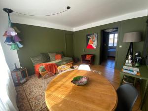 a living room with a table and a couch at Appartement cosy in Besançon +38 photos