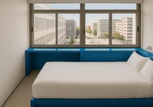 un letto in una camera con una grande finestra di Lisbon Serviced Apartments - Alvalade a Lisbona