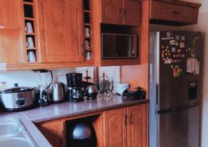 a kitchen with wooden cabinets and a stainless steel refrigerator at Still Waters in Port Alfred