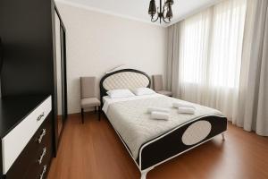Un dormitorio con una cama, una cómoda y un televisor. en Your Home Inn at Jikia's Green House-Central Tbilisi, en Tiflis