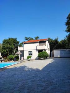 a white house with a swimming pool in front of it at Villa Solterra in Grižane