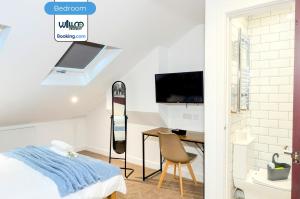 ein Schlafzimmer mit einem Bett und einem Schreibtisch mit einem Fernseher in der Unterkunft 5BR House By WillCo Property Short Lets & Serviced Accommodation Derby With Games, Parking Perfect For Contractors in Derby