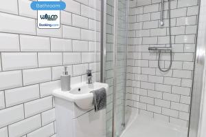 ein weißes Badezimmer mit Waschbecken und Dusche in der Unterkunft 5BR House By WillCo Property Short Lets & Serviced Accommodation Derby With Games, Parking Perfect For Contractors in Derby + 27 Fotos