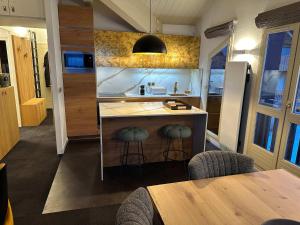 a kitchen with a counter and stools in a room at Luxury 4BR Apartment with Fireplace & Private Parking - Val Thorens in Val Thorens