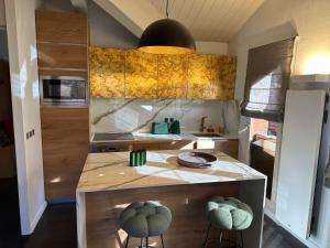 a kitchen with a counter with stools in it at Luxury 4BR Apartment with Fireplace & Private Parking - Val Thorens in Val Thorens +3 photos