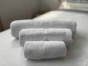 a group of white towels sitting on a bed at WIRO L'Ulivo -20 min from Malpensa and Rho Fiera in Inveruno +18 photos