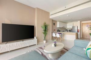 un salon avec une grande télévision à écran plat dans l'établissement Silkhaus Chic 2BDR in Radiant Boulevard, à Mushayrib