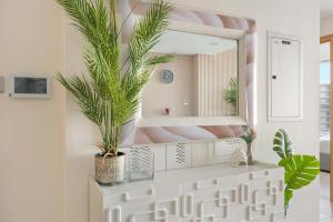 une salle de bain avec un miroir et des plantes sur un comptoir dans l'établissement Silkhaus Chic 2BDR in Radiant Boulevard, à Mushayrib 22 autres photos