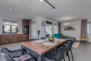 Una cocina y una sala de estar con mesa y sillas. en Villa Taralis with heated pool, en Kaštel
