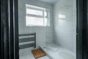 a white bathroom with a shower and a window at Oxford Modern Living - City Centre in Oxford +35 photos