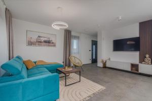 Una sala de estar con un sofá azul y un televisor en Villa Taralis with heated pool, en Kaštel