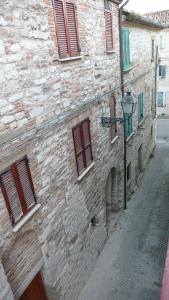 Serra SantʼAbbondio的住宿－Romantico B&B，一座古老的石头建筑,旁边是街道灯