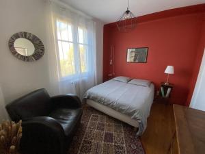 a bedroom with a bed and a chair and a mirror at Appartement cosy in Besançon